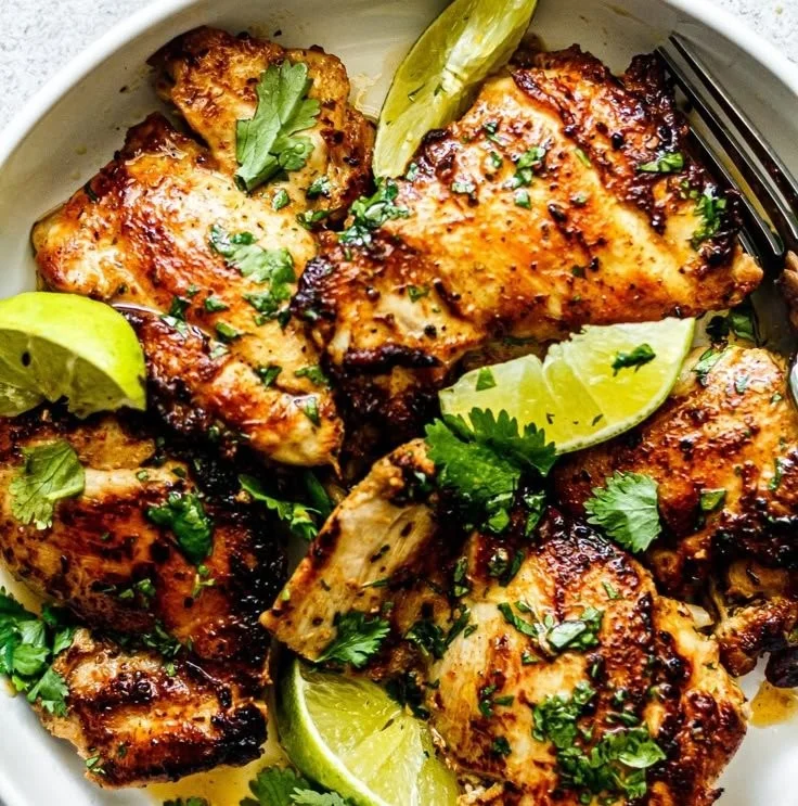 Cilantro-Lime Chicken Thighs with Crispy Skin on a plate garnished with lime slices