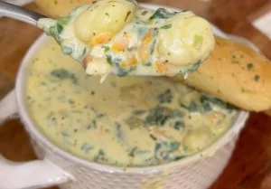 Bowl of creamy chicken gnocchi soup with fresh herbs and vegetables