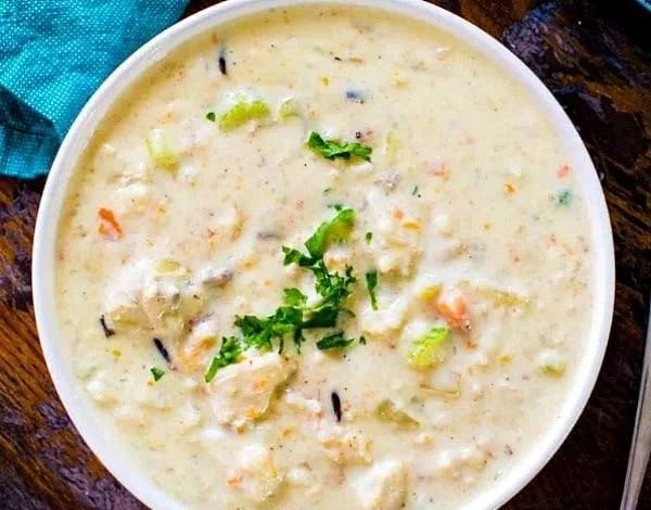 Bowl of creamy chicken wild rice soup with vegetables and herbs